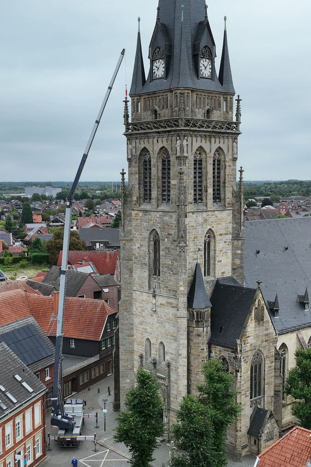 Klaas K2350 mit ausgefahrenem Ausleger neben einem Kirchturm